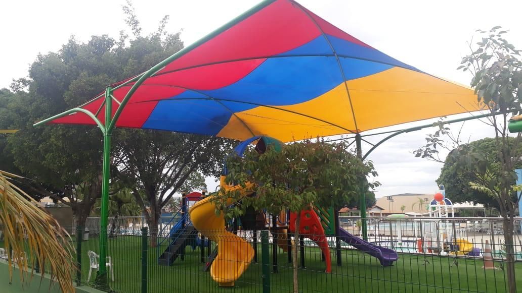 Um playground com um guarda-chuva colorido sobre ele