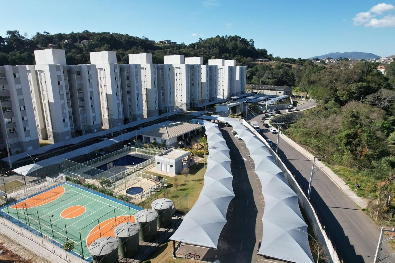 Uma vista aérea de uma área residencial com uma quadra de basquete e guarda-sóis.
