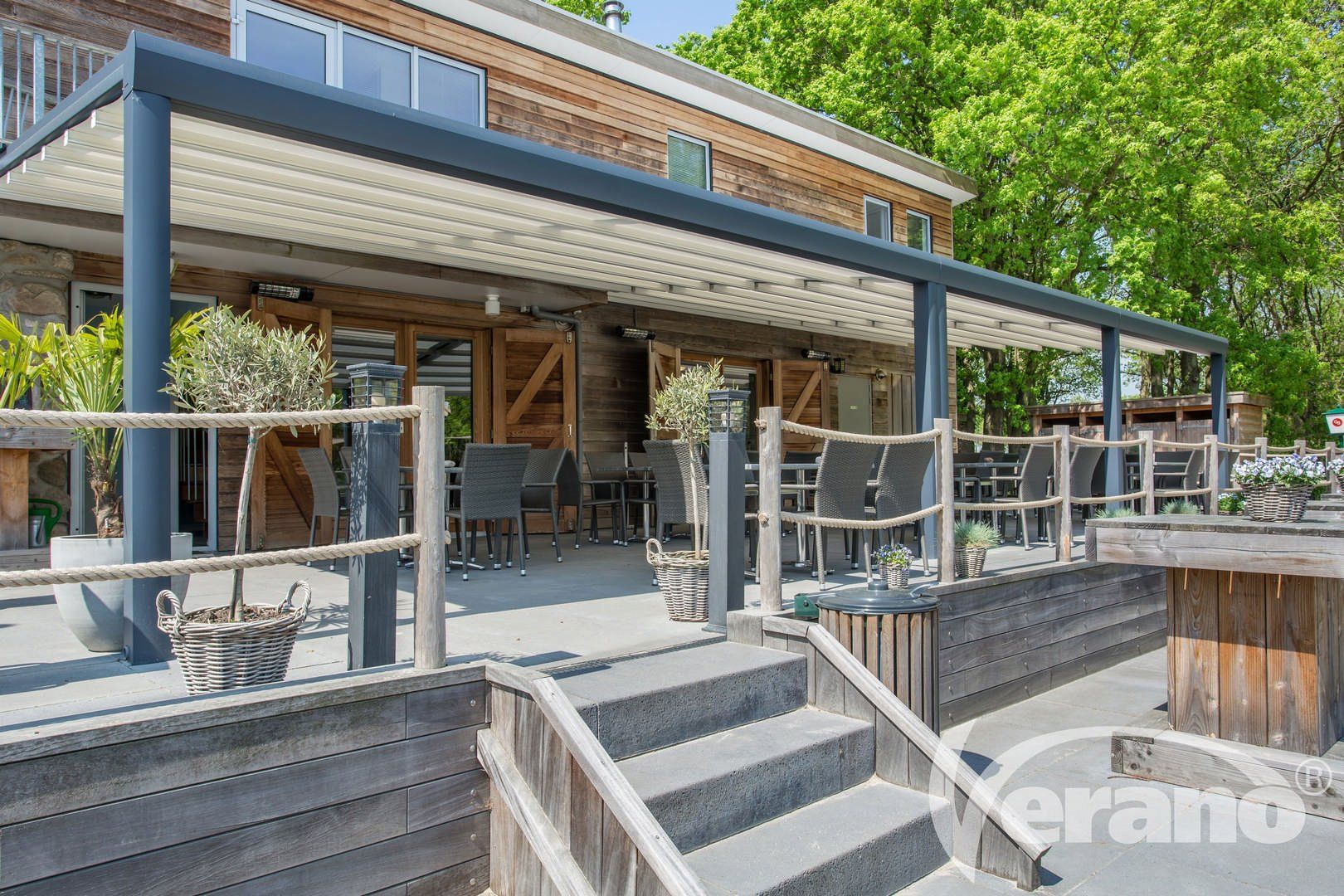 Een restaurant met een pergola en een trap ernaartoe.