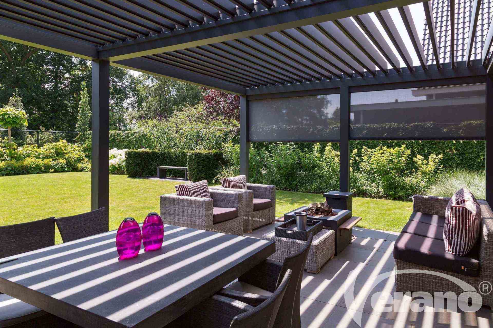 Een terras met een tafel en stoelen onder een pergola.