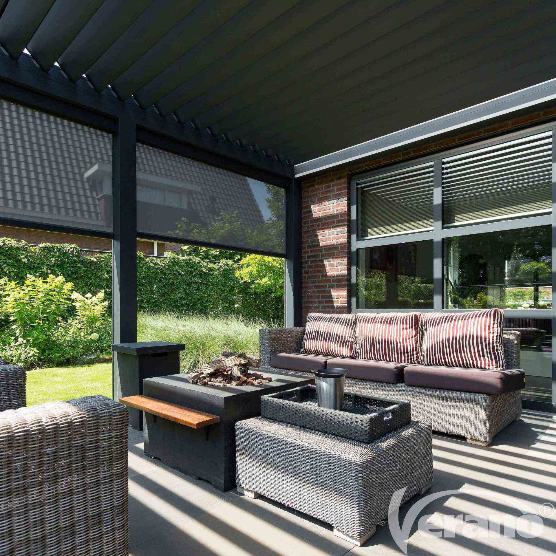 Een terras met rieten meubels en een vuurplaats