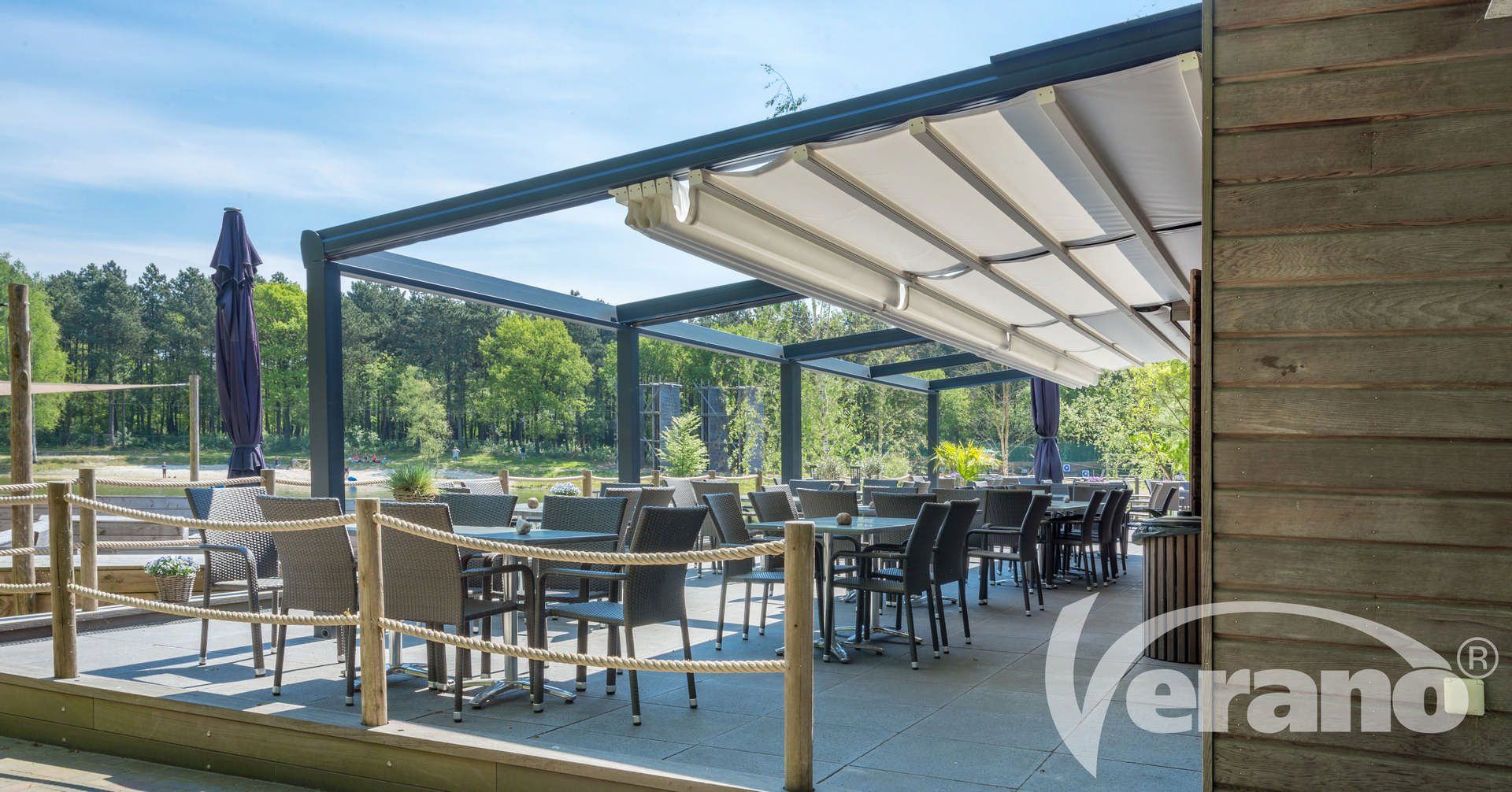 Een restaurant met tafels en stoelen onder een luifel.