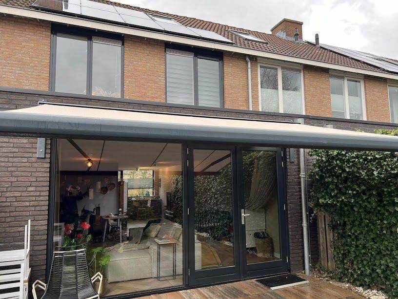 Een huis met een terras en een luifel erover.
