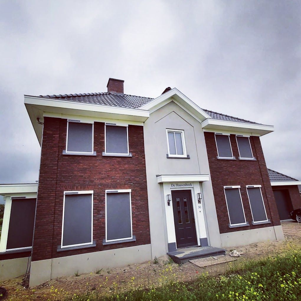 Een groot bakstenen huis met veel ramen