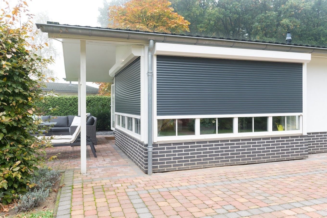 Een klein huisje met een zwart luik voor het raam.