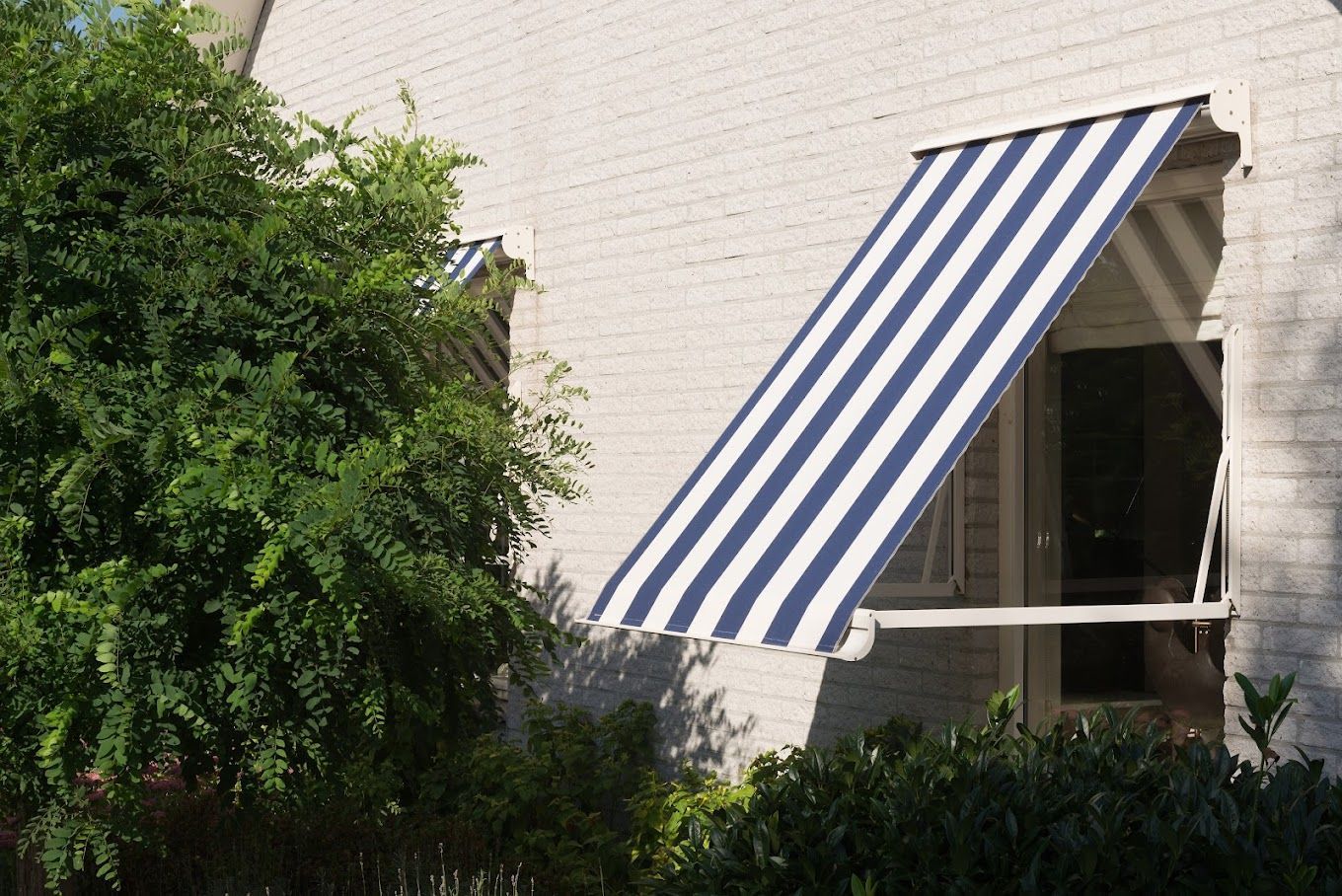 Een blauw-wit gestreepte luifel hangt boven een raam