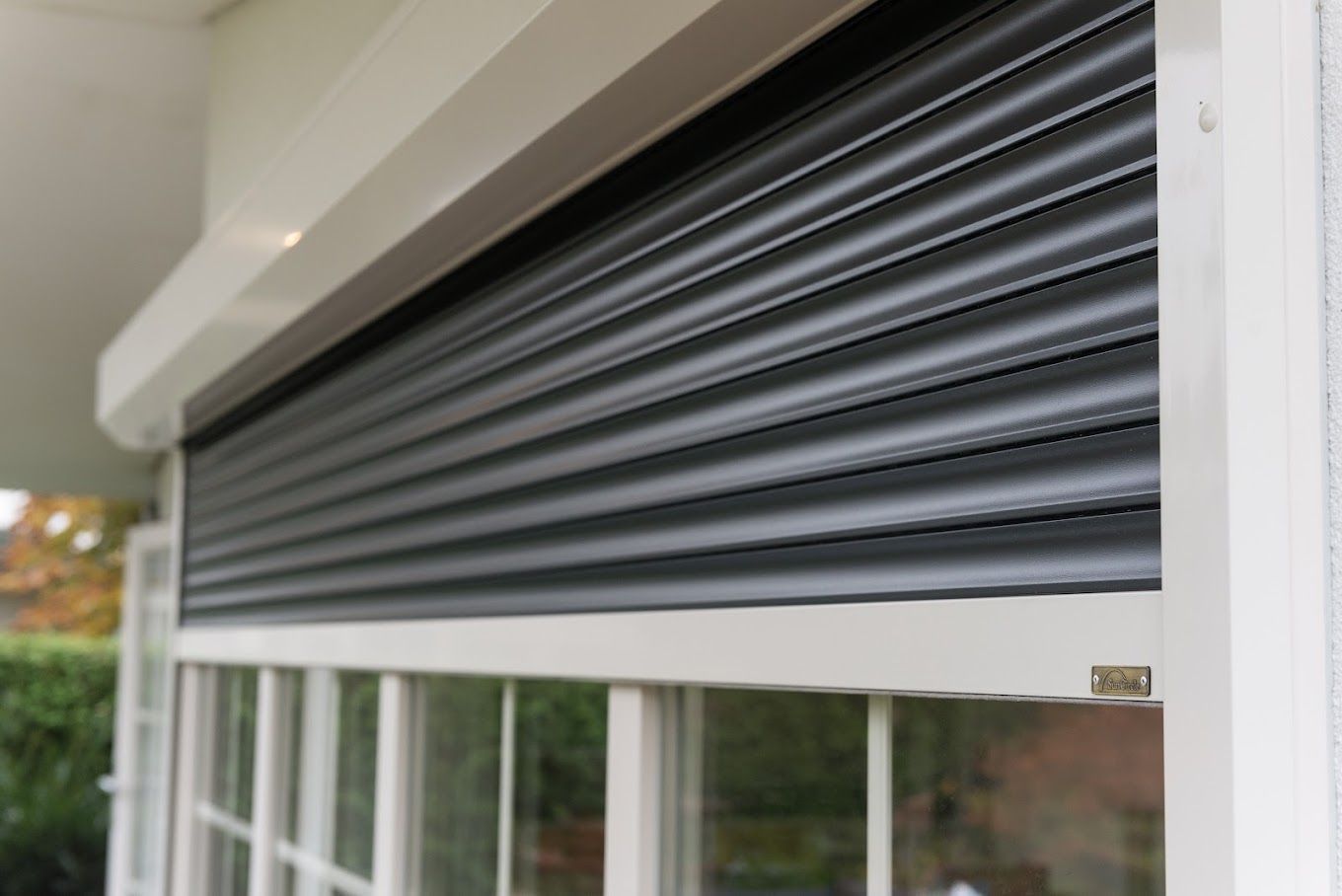 Een close-up van een raam met een rolluik ervoor.