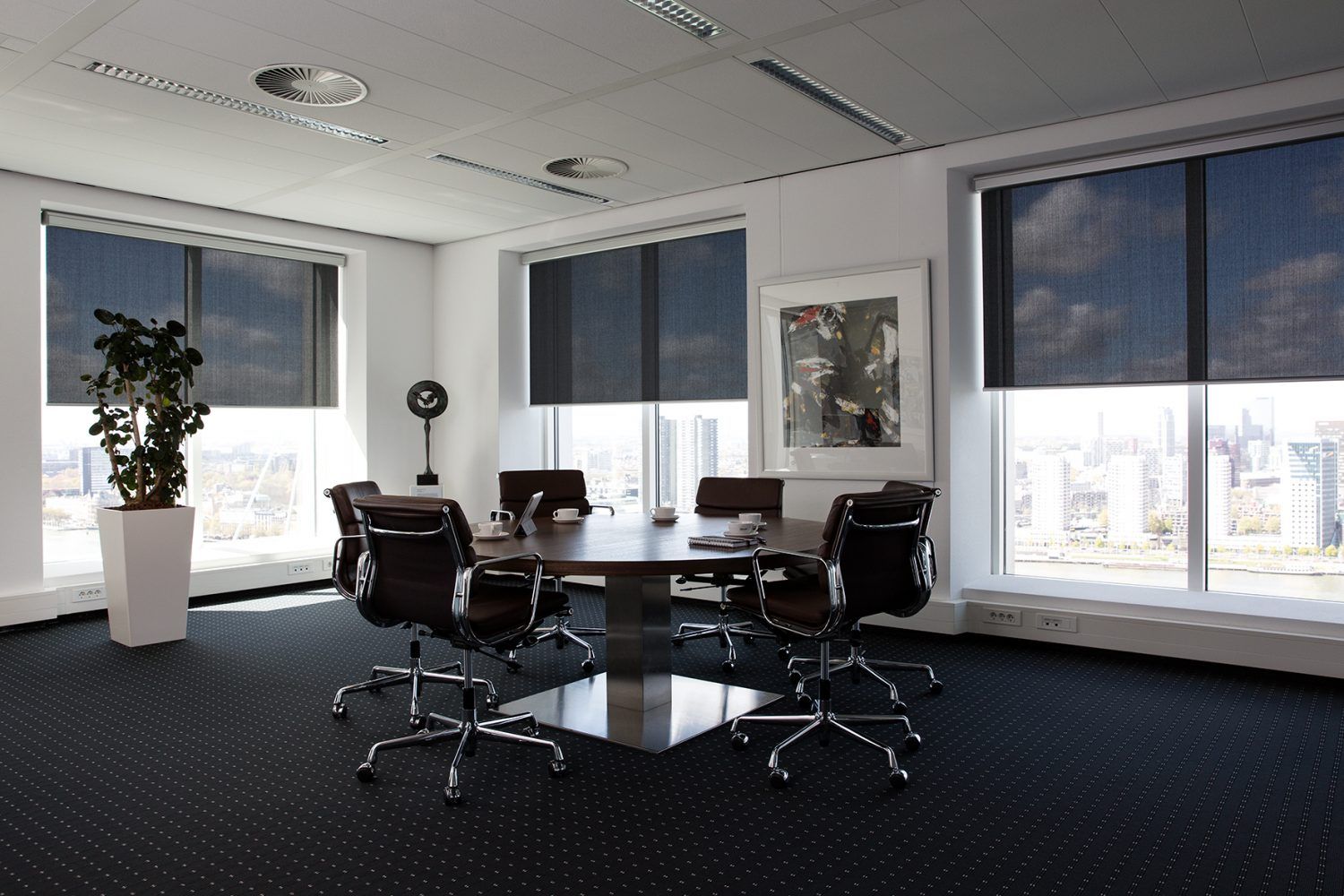 Een conferentieruimte met een tafel en stoelen erin