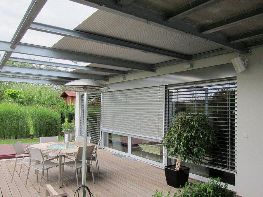 Een terras met een tafel en stoelen onder een luifel.