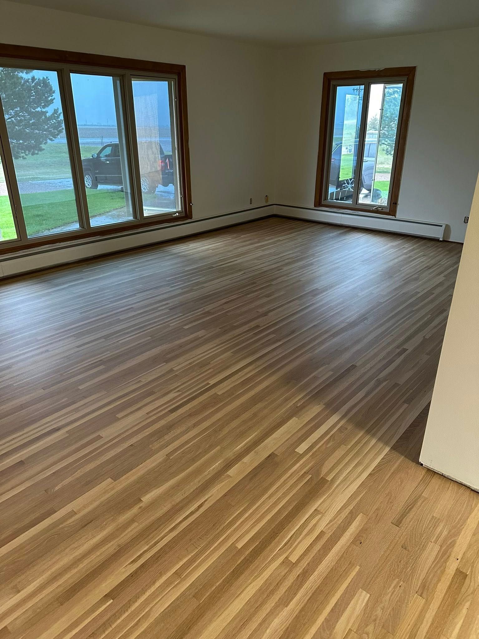 A living room with hardwood floors and lots of windows.