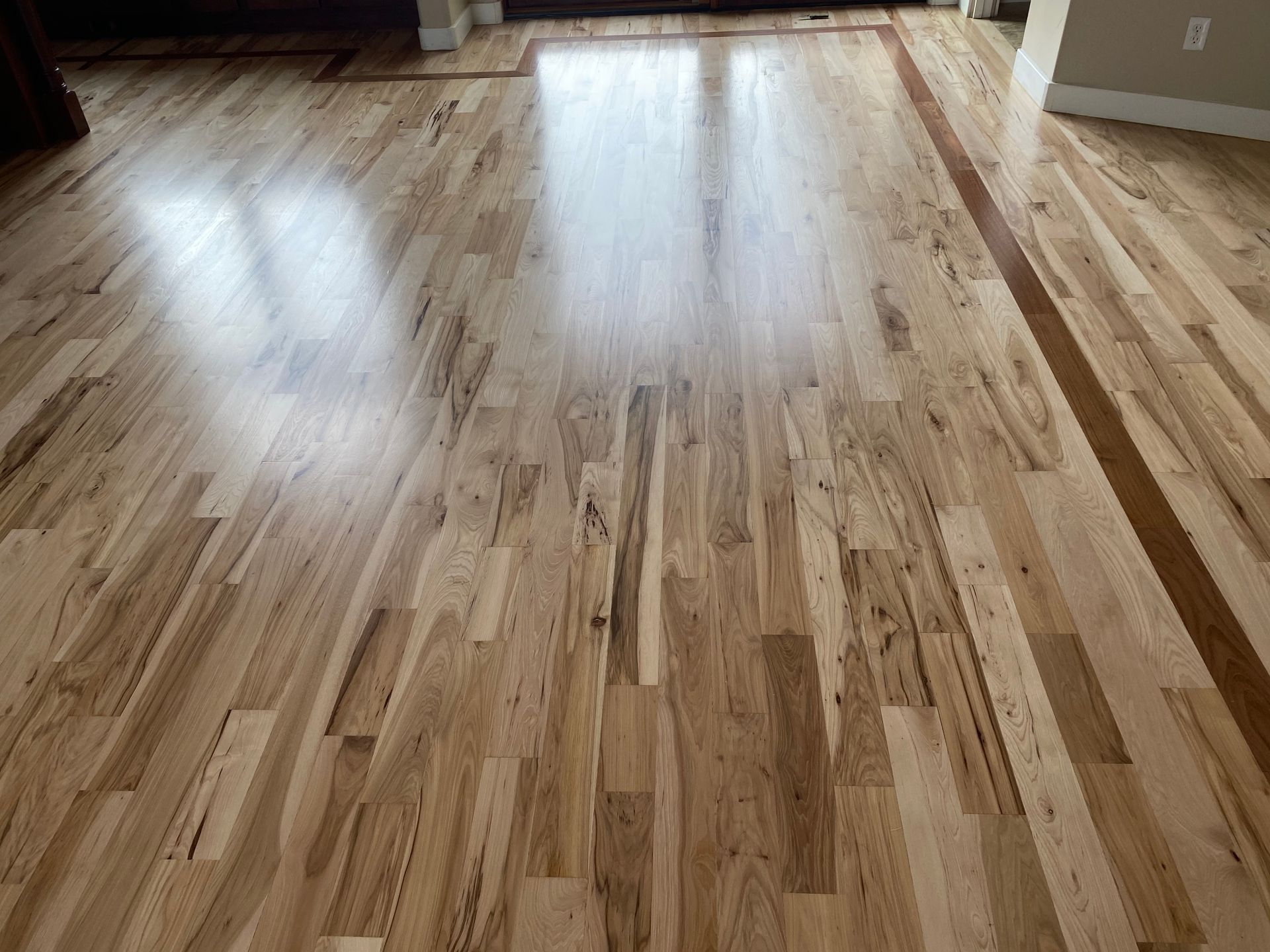 A wooden floor in a living room with a wooden border