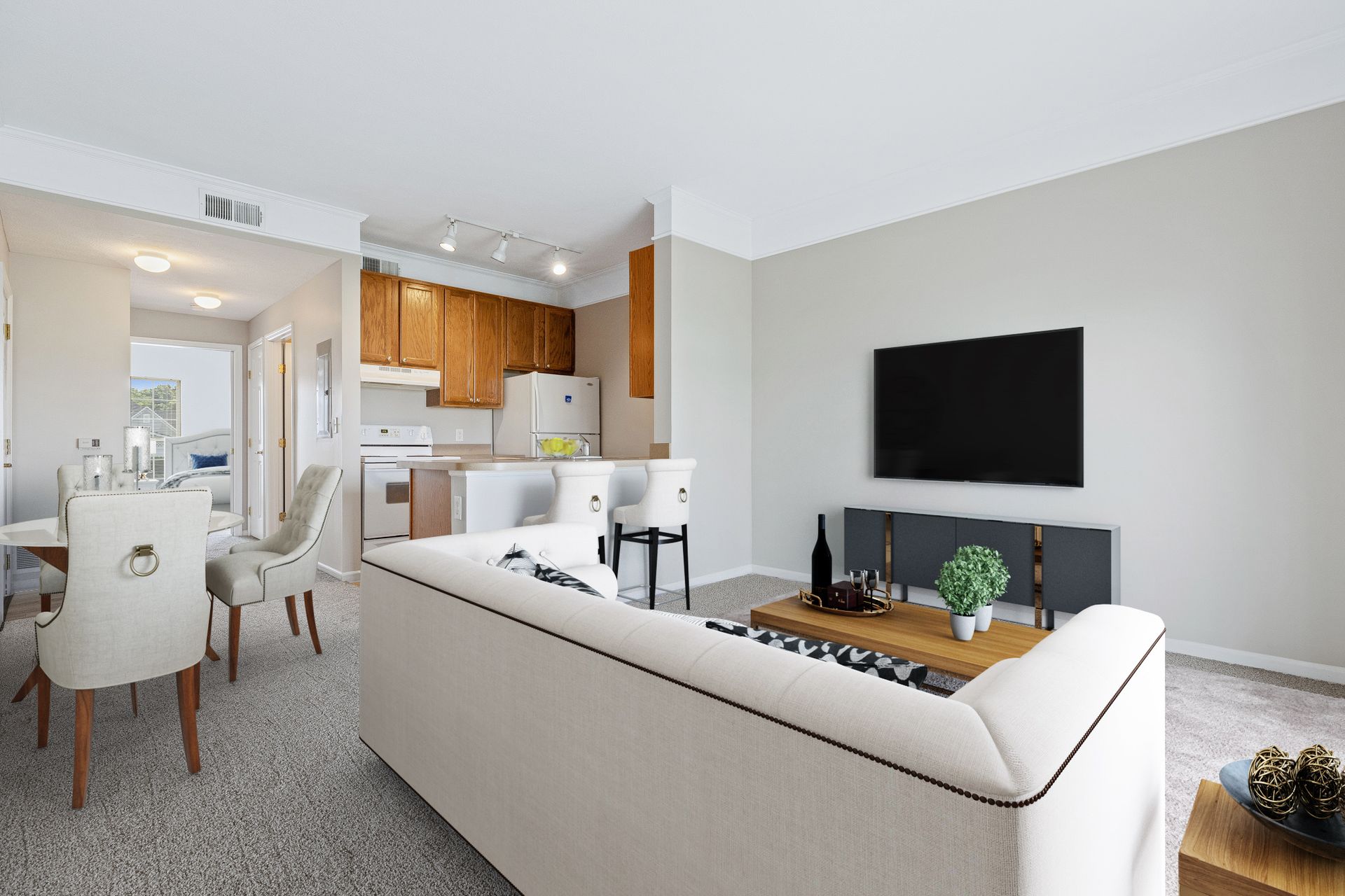 A living room with a white couch and a flat screen tv.