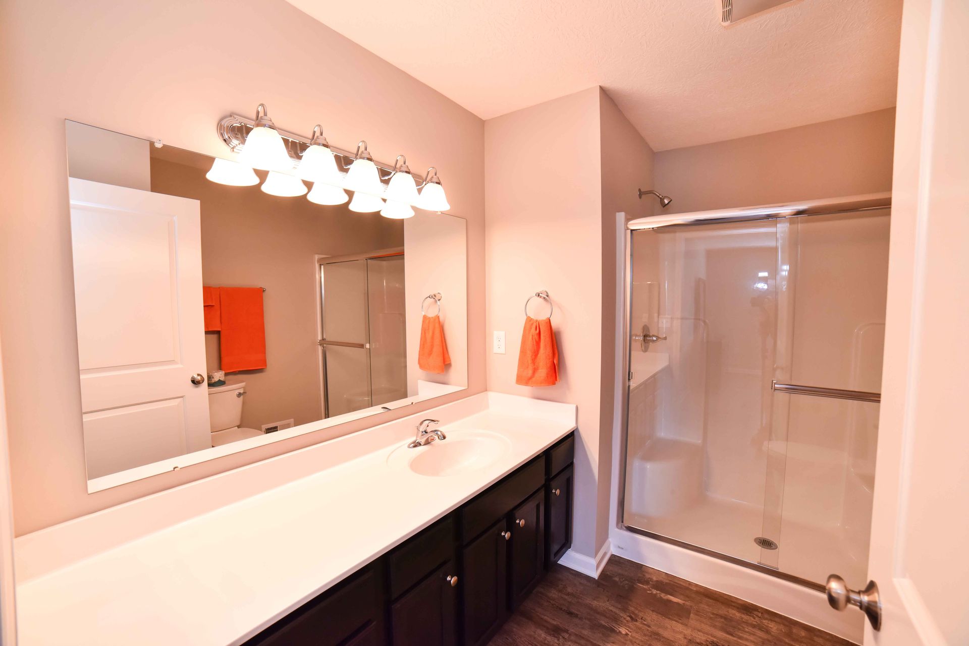 A bathroom with a double sink and a walk in shower.