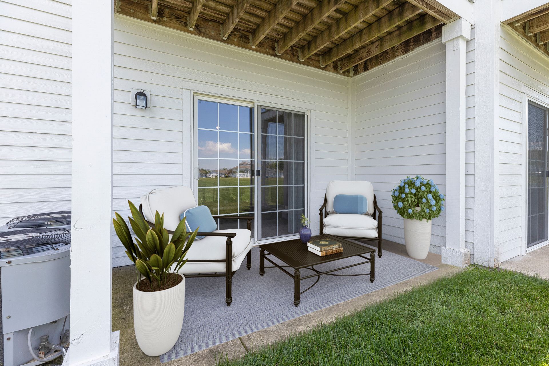 A patio with chairs , a coffee table and a grill.