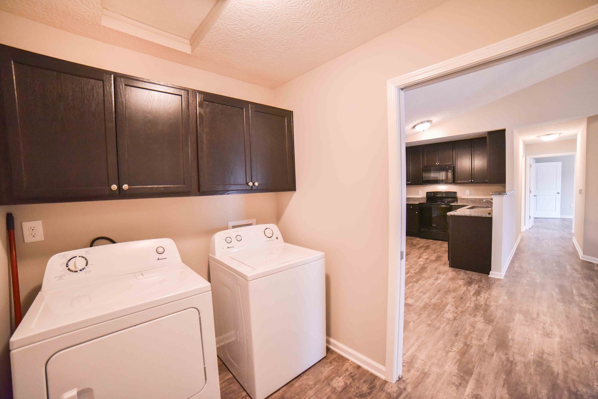A washer and dryer are in a laundry room next to a kitchen.