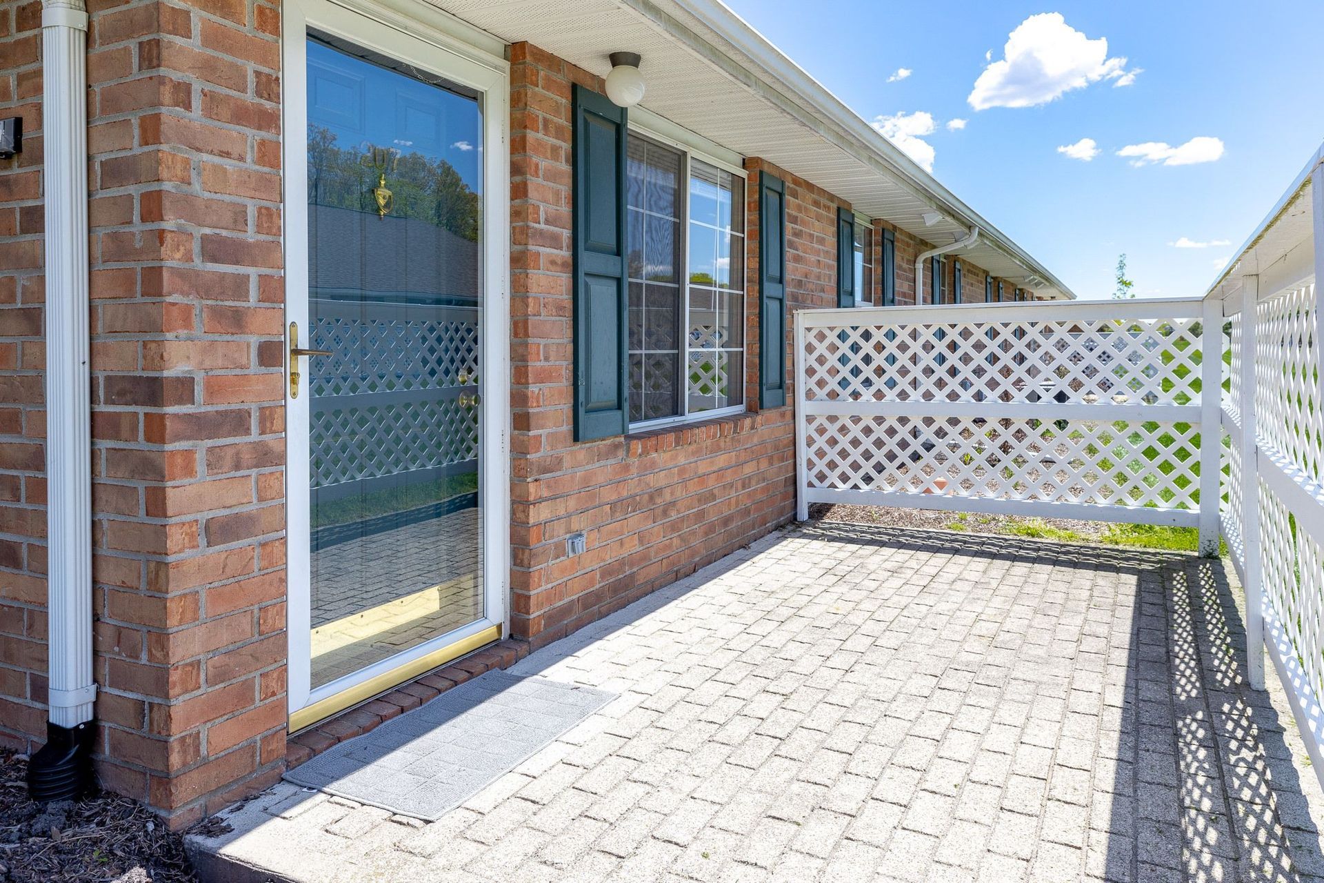 A brick house with a patio in front of it.