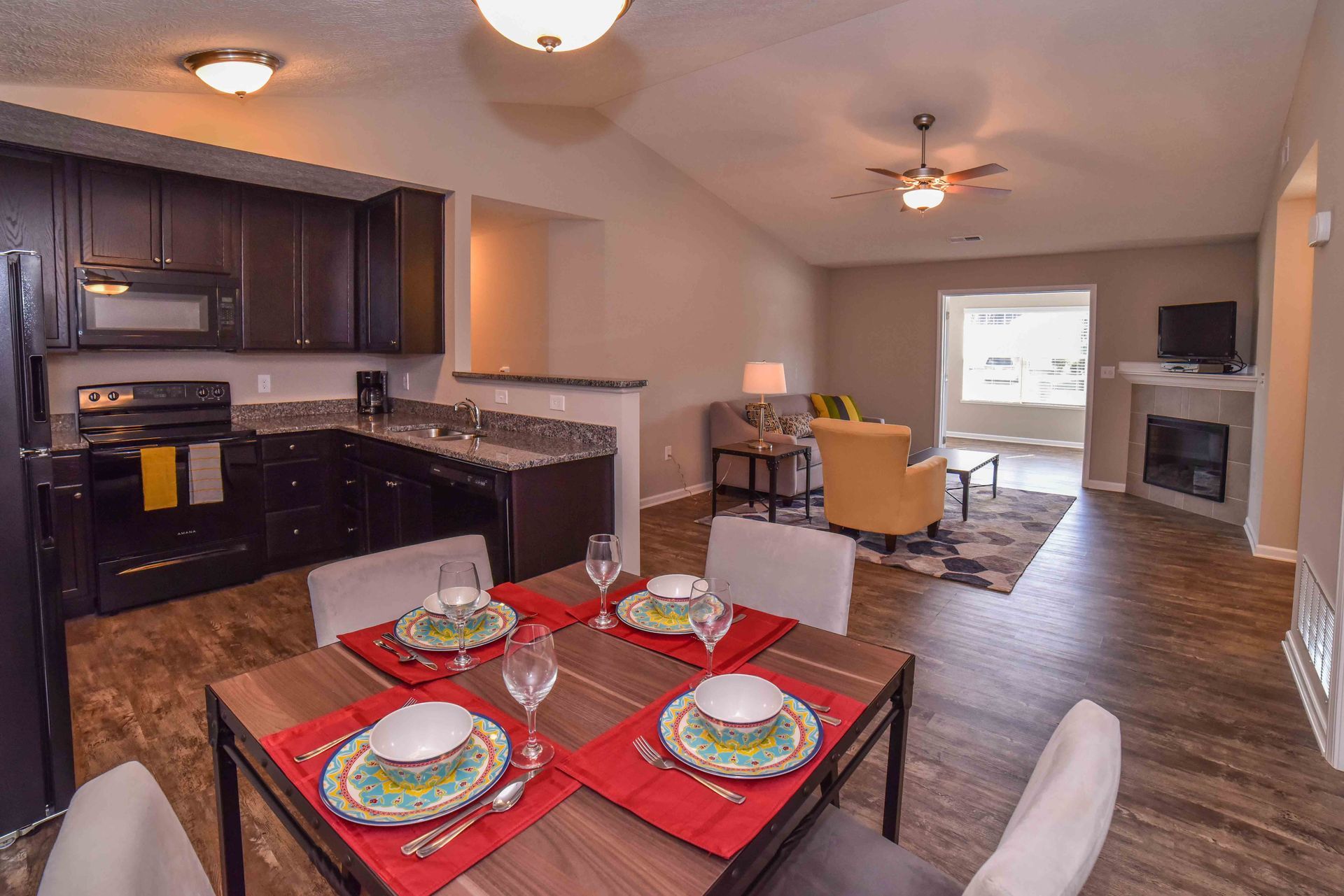 A kitchen and dining room in a house with a table set for dinner.