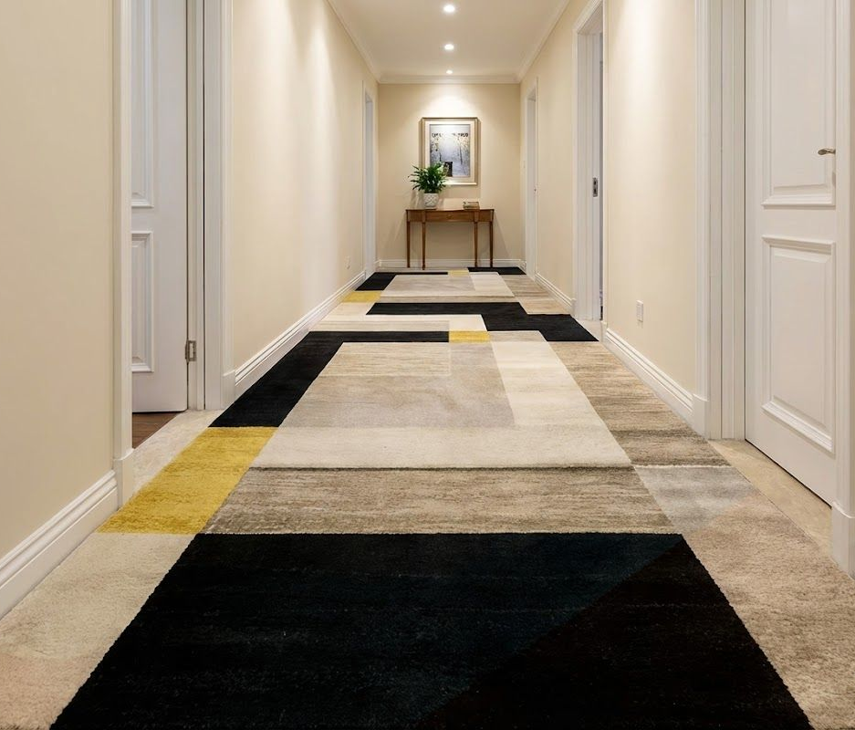 Empty room with gray walls, two windows, ceiling fan, and beige carpet.
