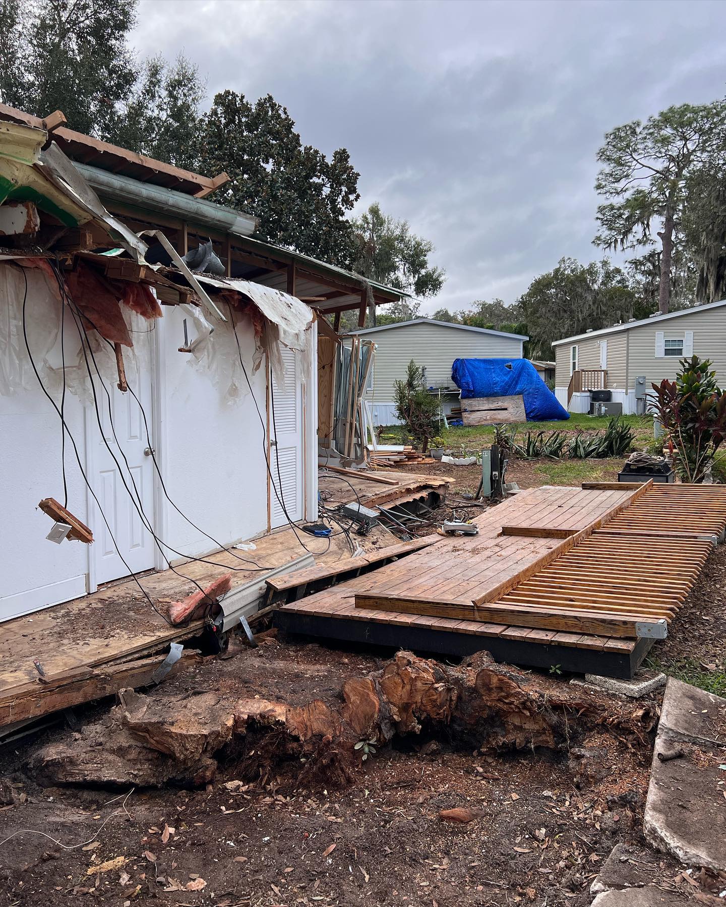 Debris and damaged buildings in a mobile home park after a storm.