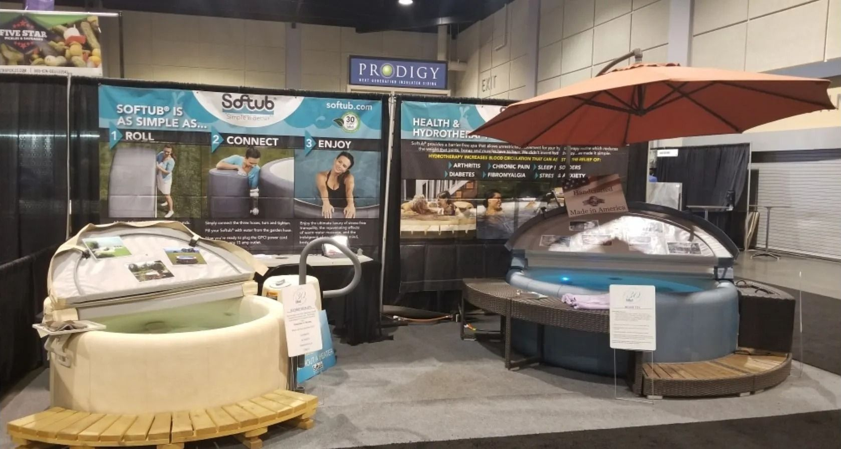 A spa showroom featuring hot tubs with umbrellas and promotional signage.