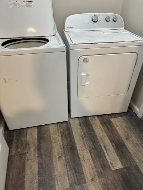 White washing machine and dryer set in a room with wood-look flooring.