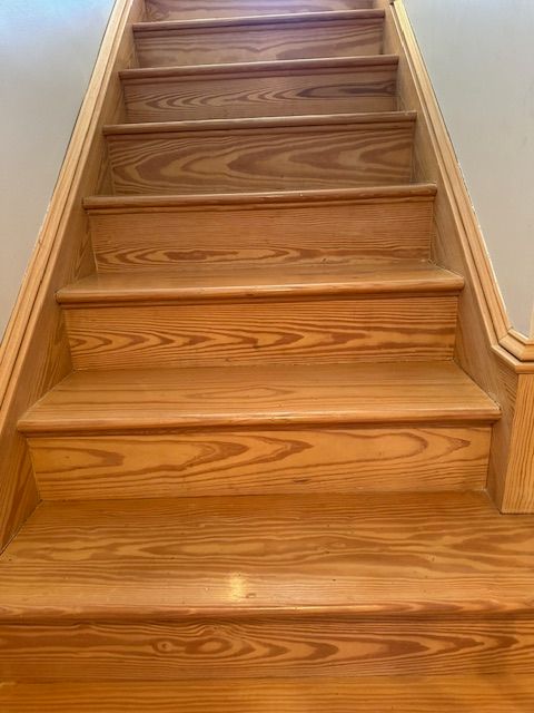 Wooden staircase with natural grain, ascending upwards.
