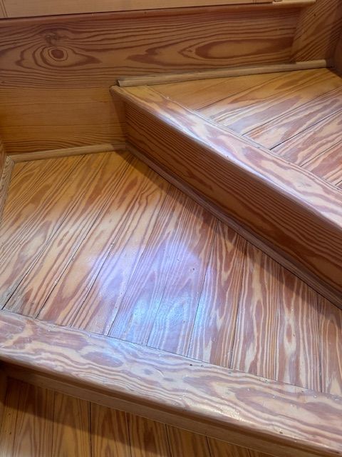 Wooden staircase with light-colored, striated wood and a slightly glossy finish.