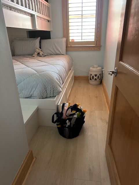 A small bedroom with a built-in bunk bed. Tools sit on the floor near the doorway.
