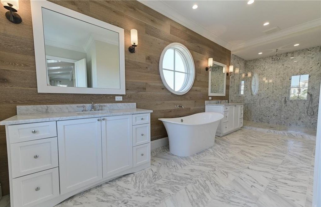 Bathroom with white cabinets, freestanding tub, and textured wood wall.
