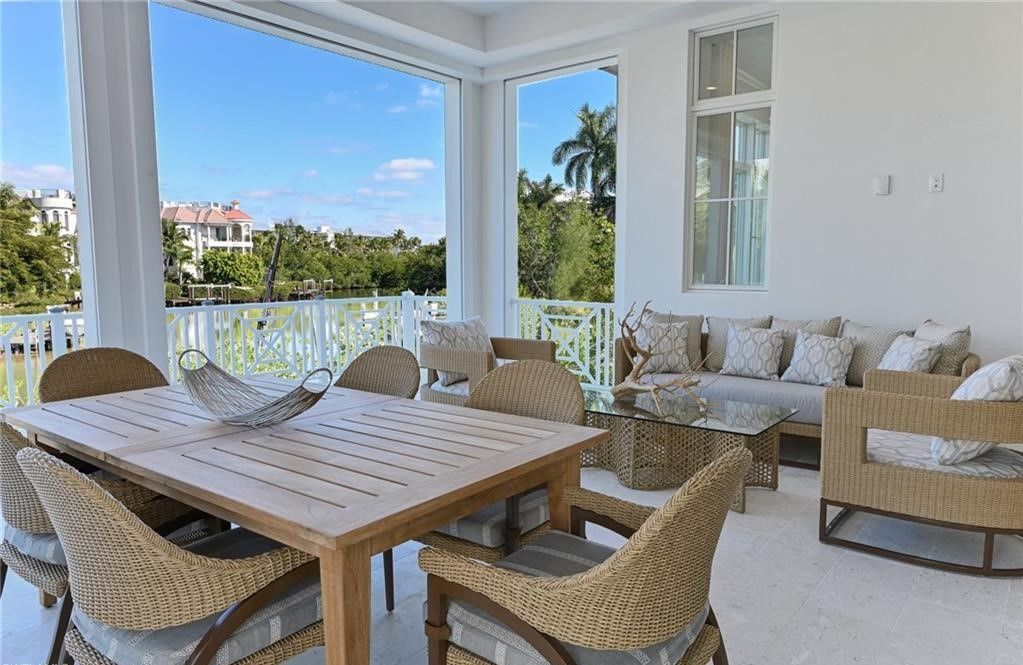 Covered patio with wicker furniture and a view of a waterway.