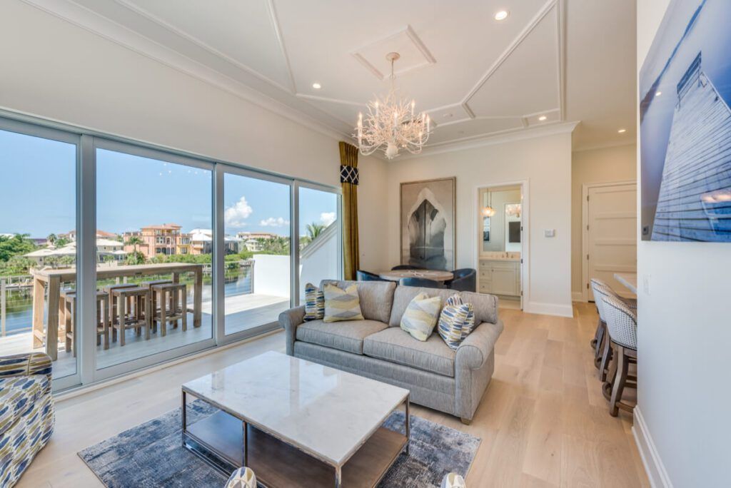 Spacious, well-lit living room with large windows, balcony, and contemporary furniture.