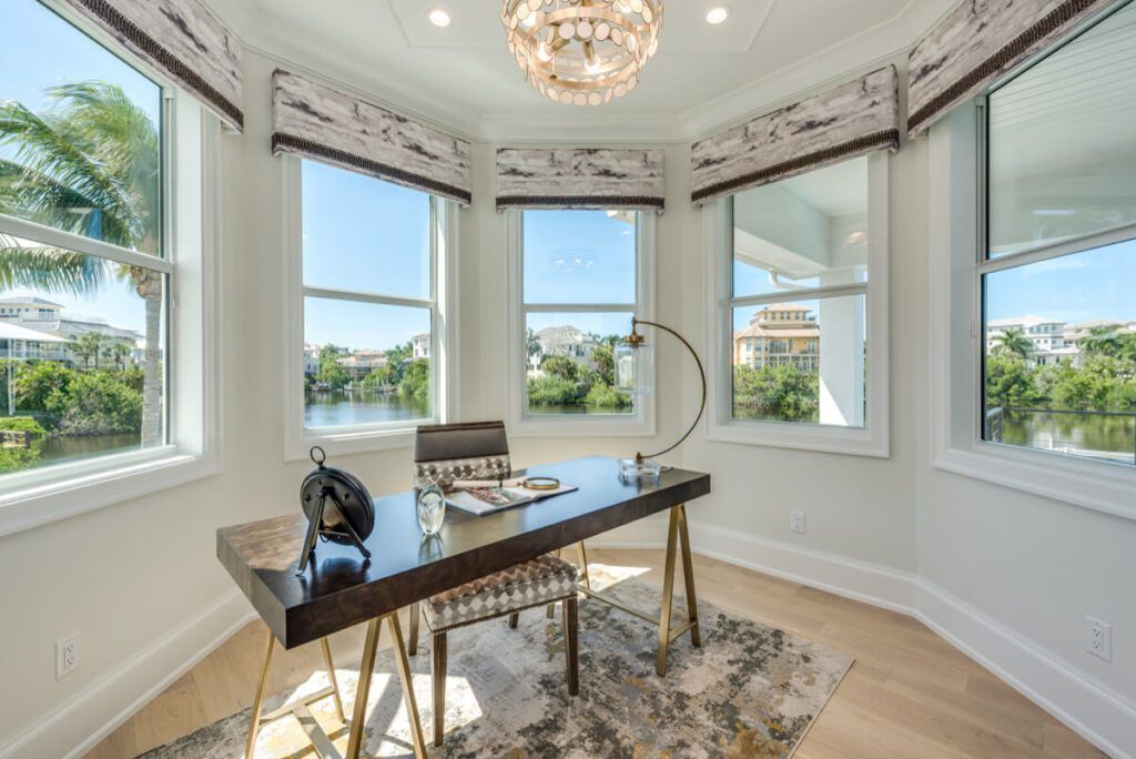 Office nook with desk, chair, and windows overlooking water.