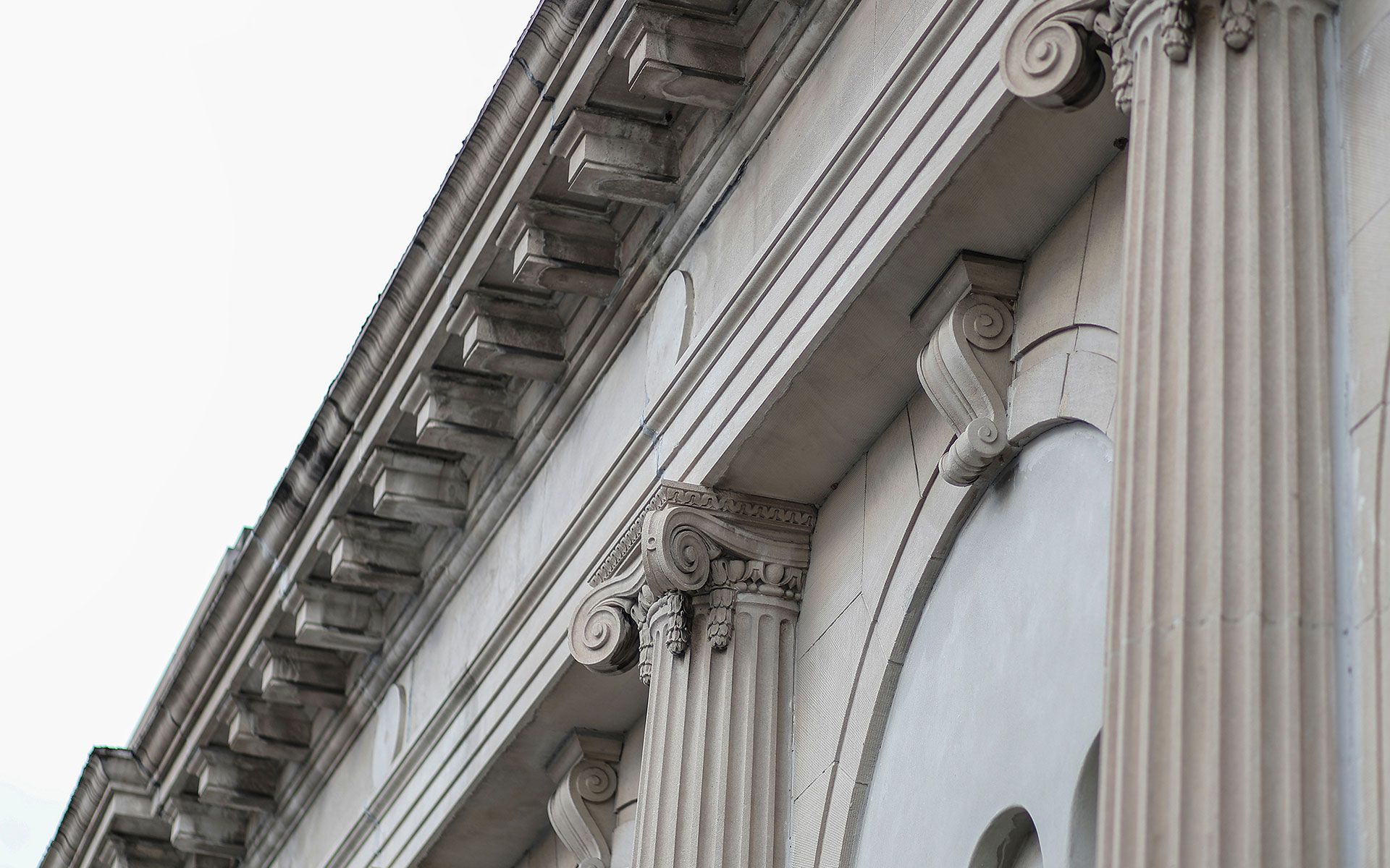 Classical building facade with fluted columns, ornate capitals, and decorative cornice.
