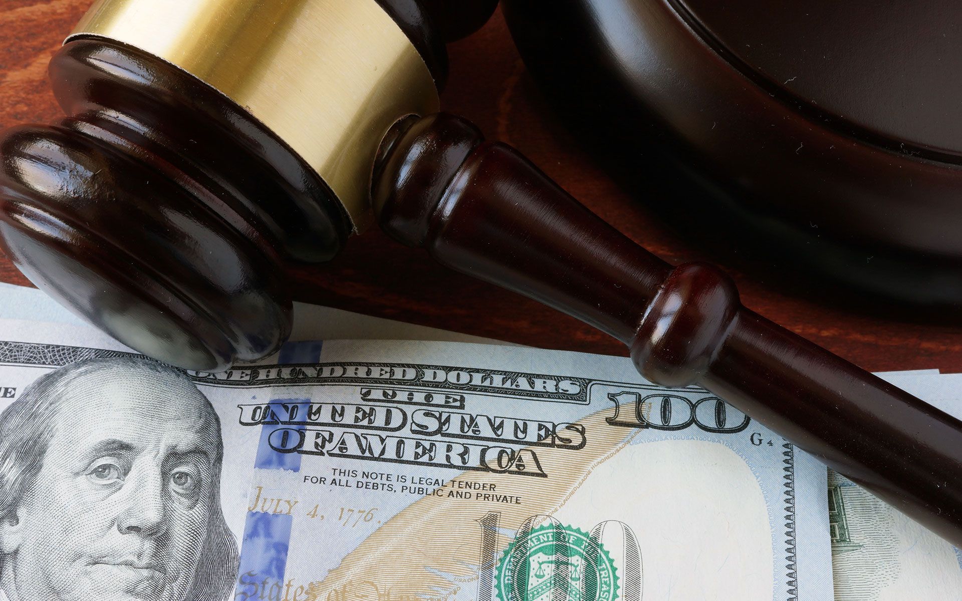 Wooden gavel on top of US $100 bill.