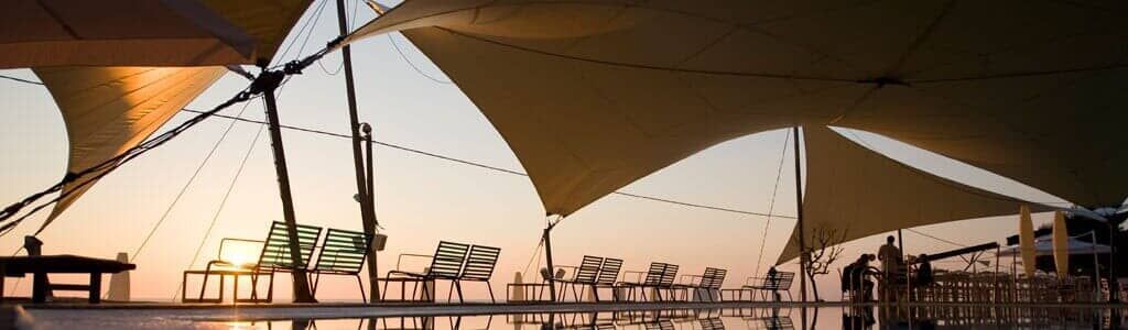 Un paraguas grande cuelga sobre un cuerpo de agua.