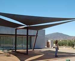 Una mujer está parada bajo un paraguas frente a una casa.