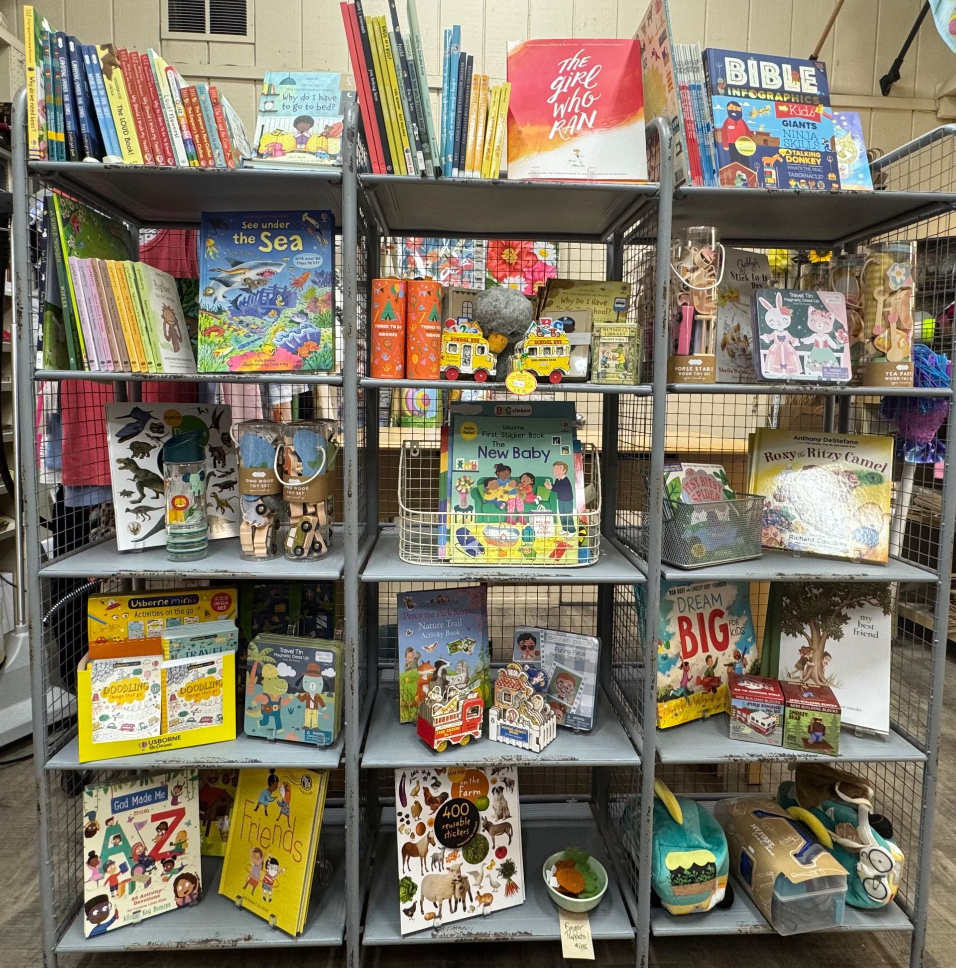 A display of books and toys in a store with a sign that says bible
