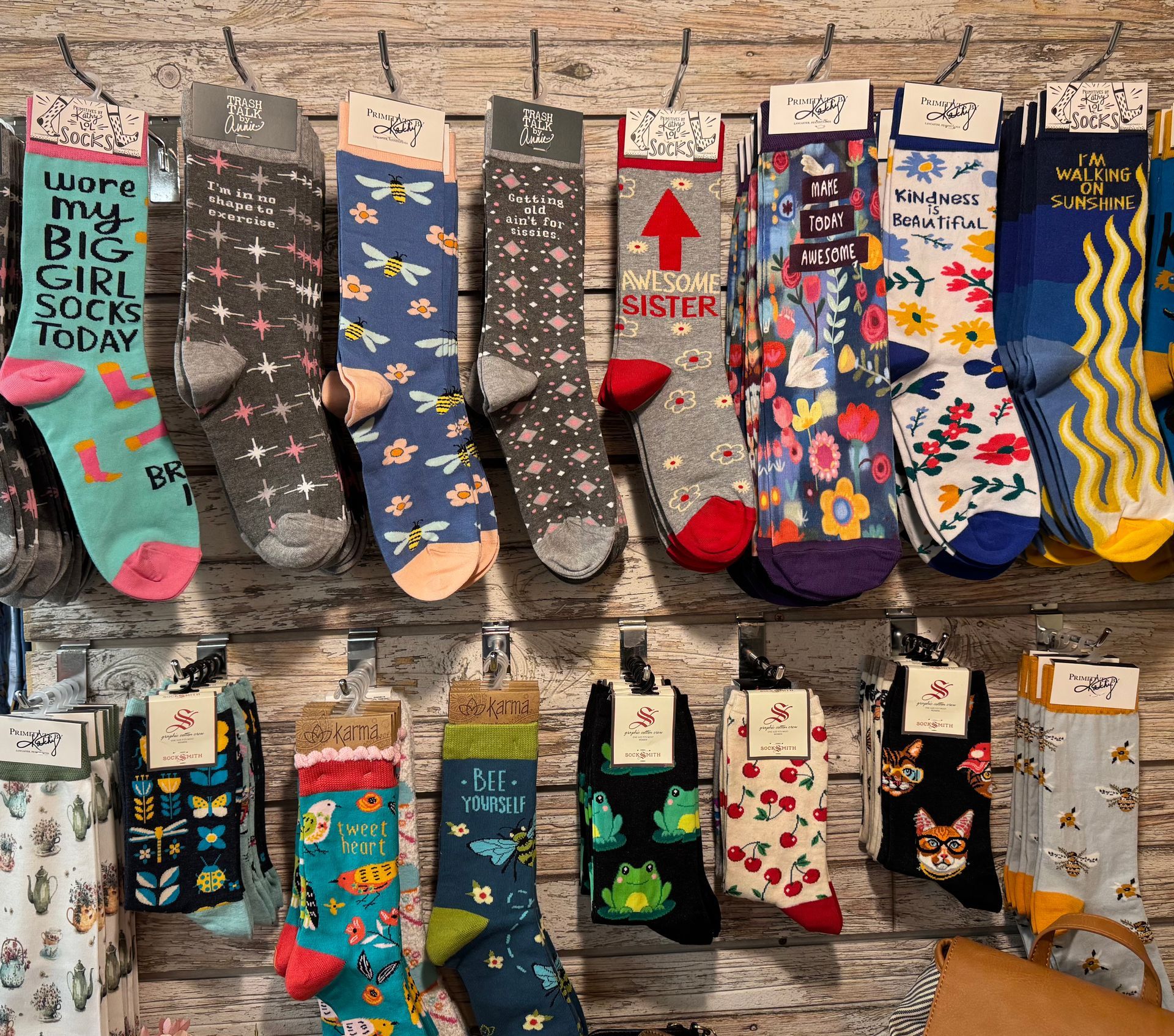 A variety of socks are hanging on a wall in a store.