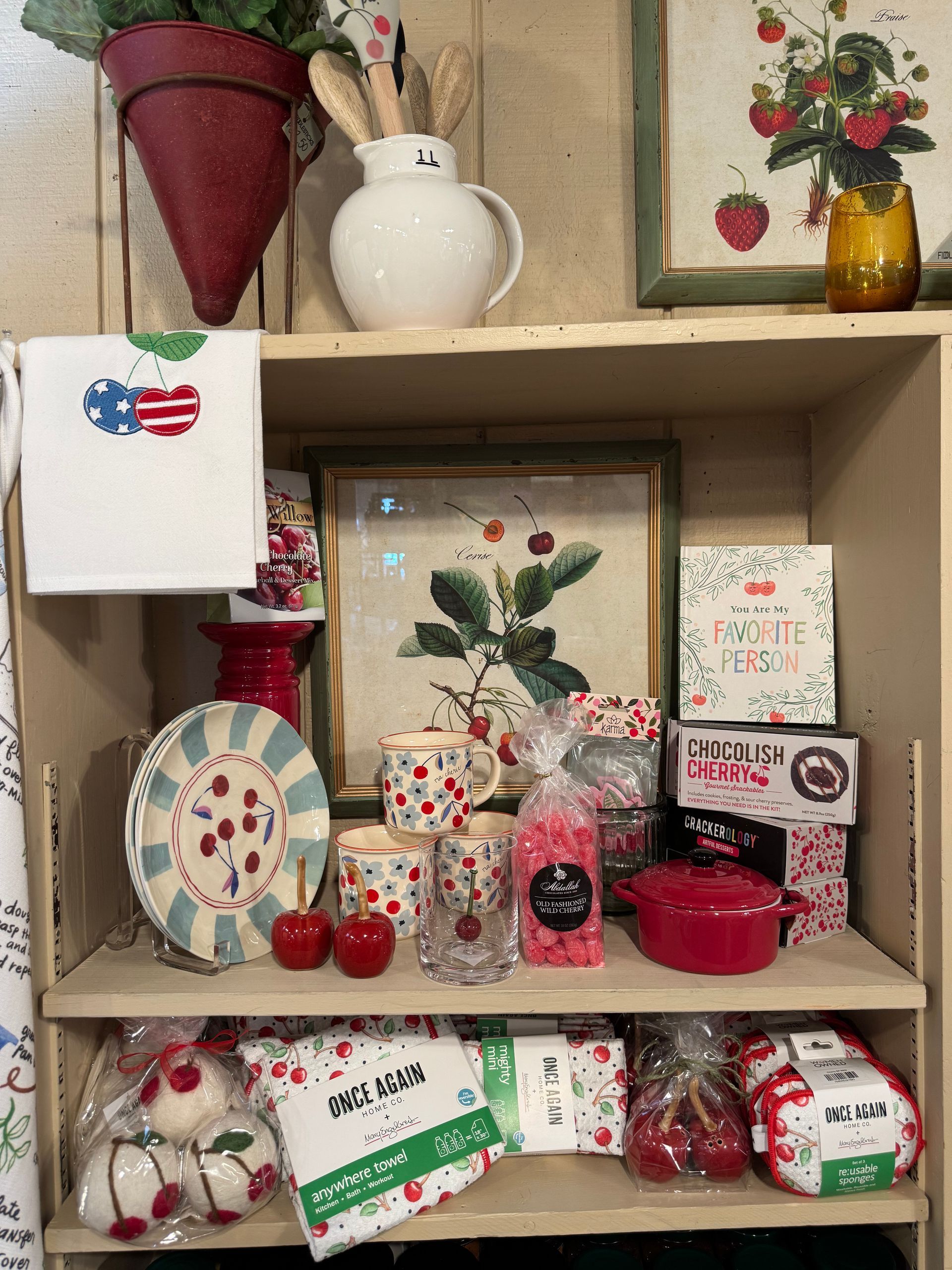 A shelf filled with a variety of cherry themed items.