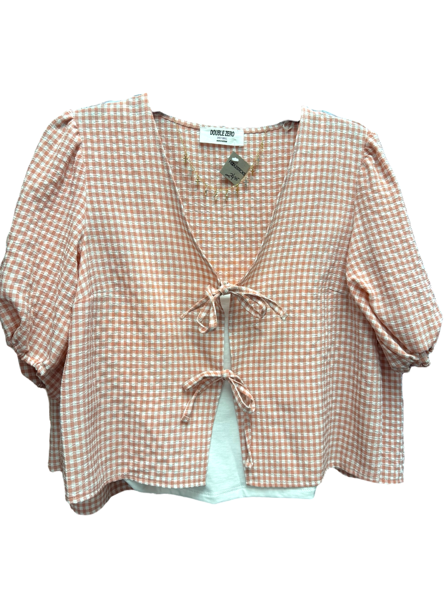 A pink plaid crop top with short sleeves and a tie in the front.