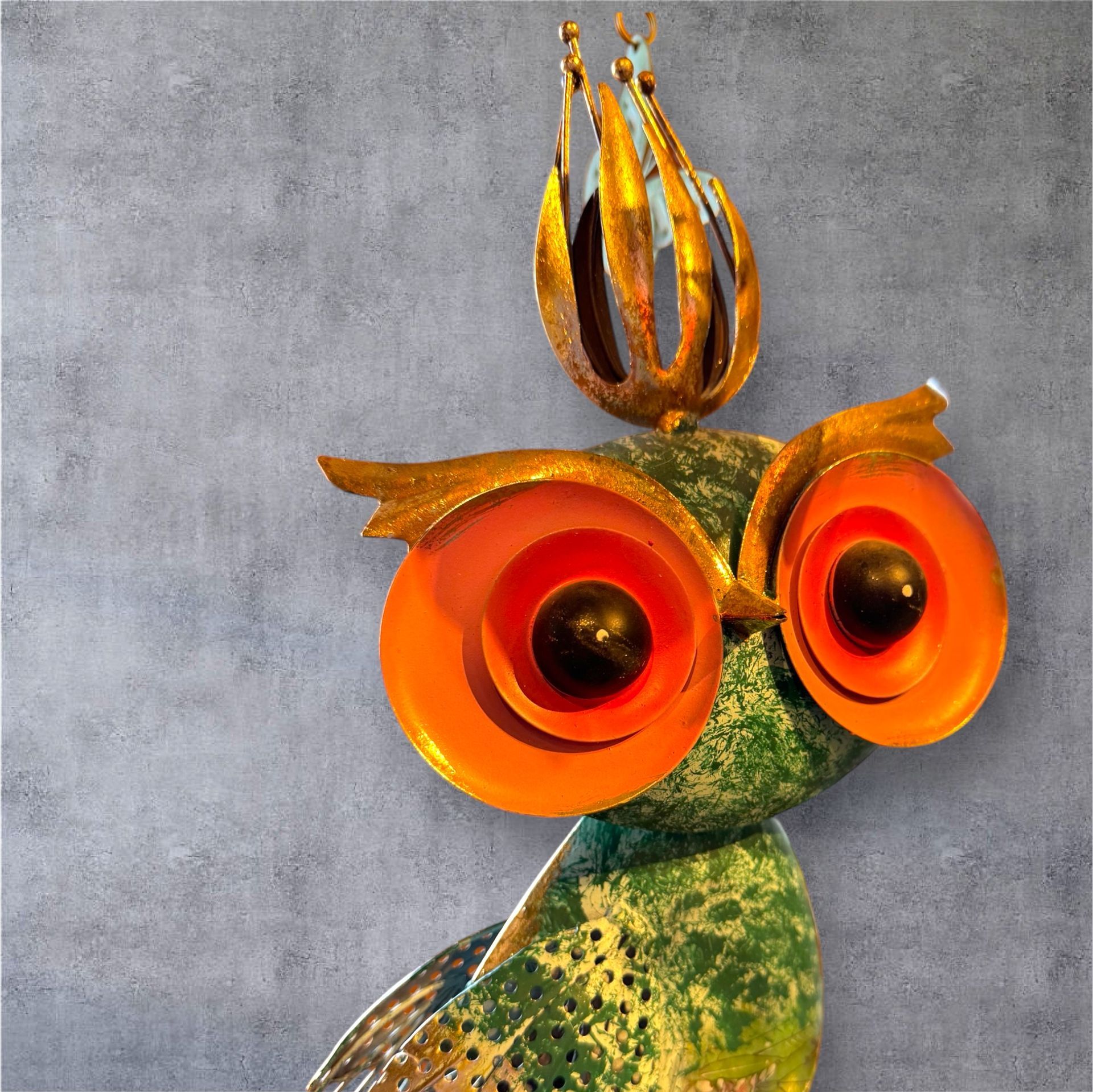 A green and orange owl with a crown on its head