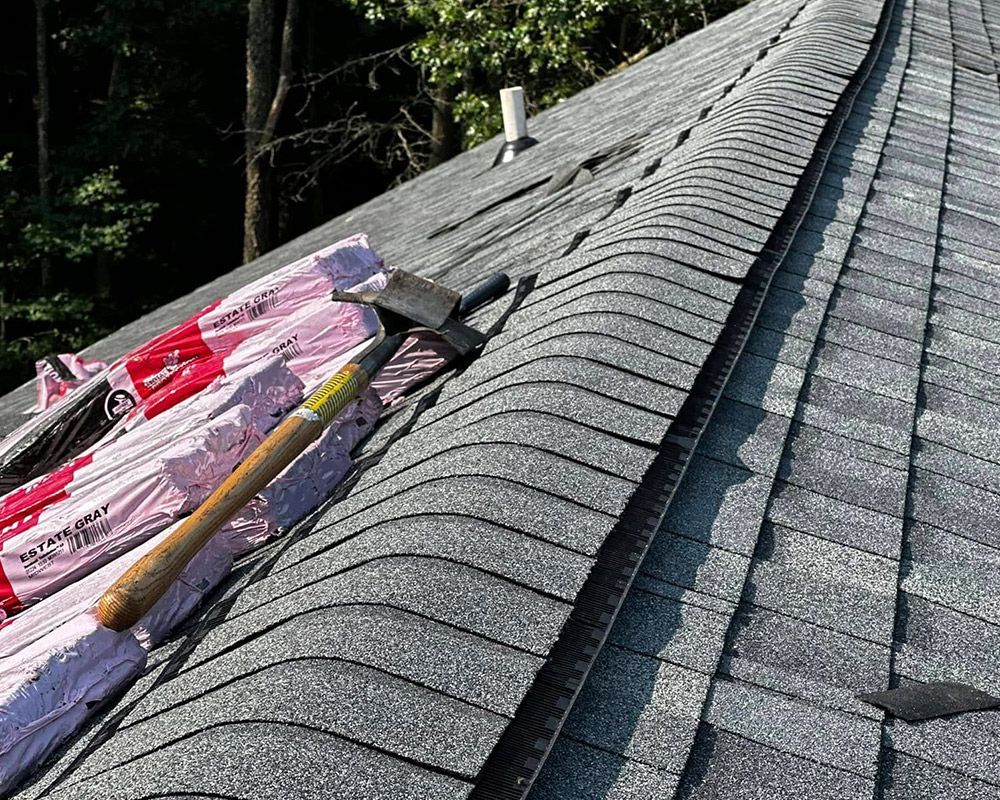 A roof with shingles and a hammer on it.