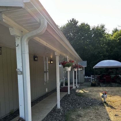 A house with a porch and a white gutter.