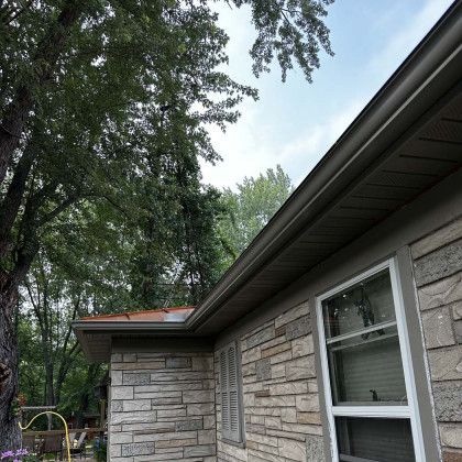A house with a gutter on the side of it and a window.