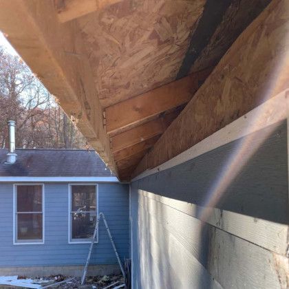 A blue house with a wooden roof is being built.
