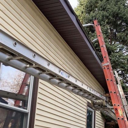 A close up of a wooden roof with snow on it and a window.