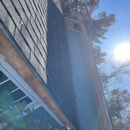 A close up of a gutter on the side of a house.