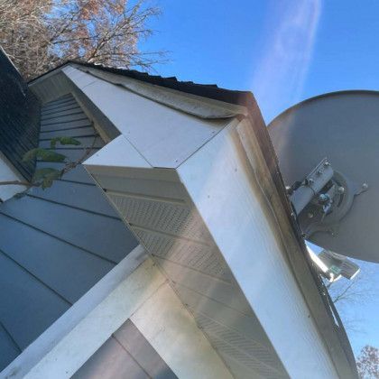 A satellite dish is mounted on the roof of a house.