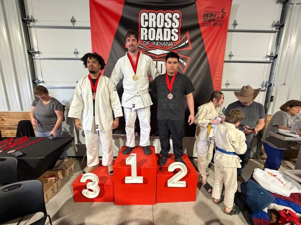 Podium ceremony with medalists on 1st, 2nd, and 3rd place stands at a Cross Roads event