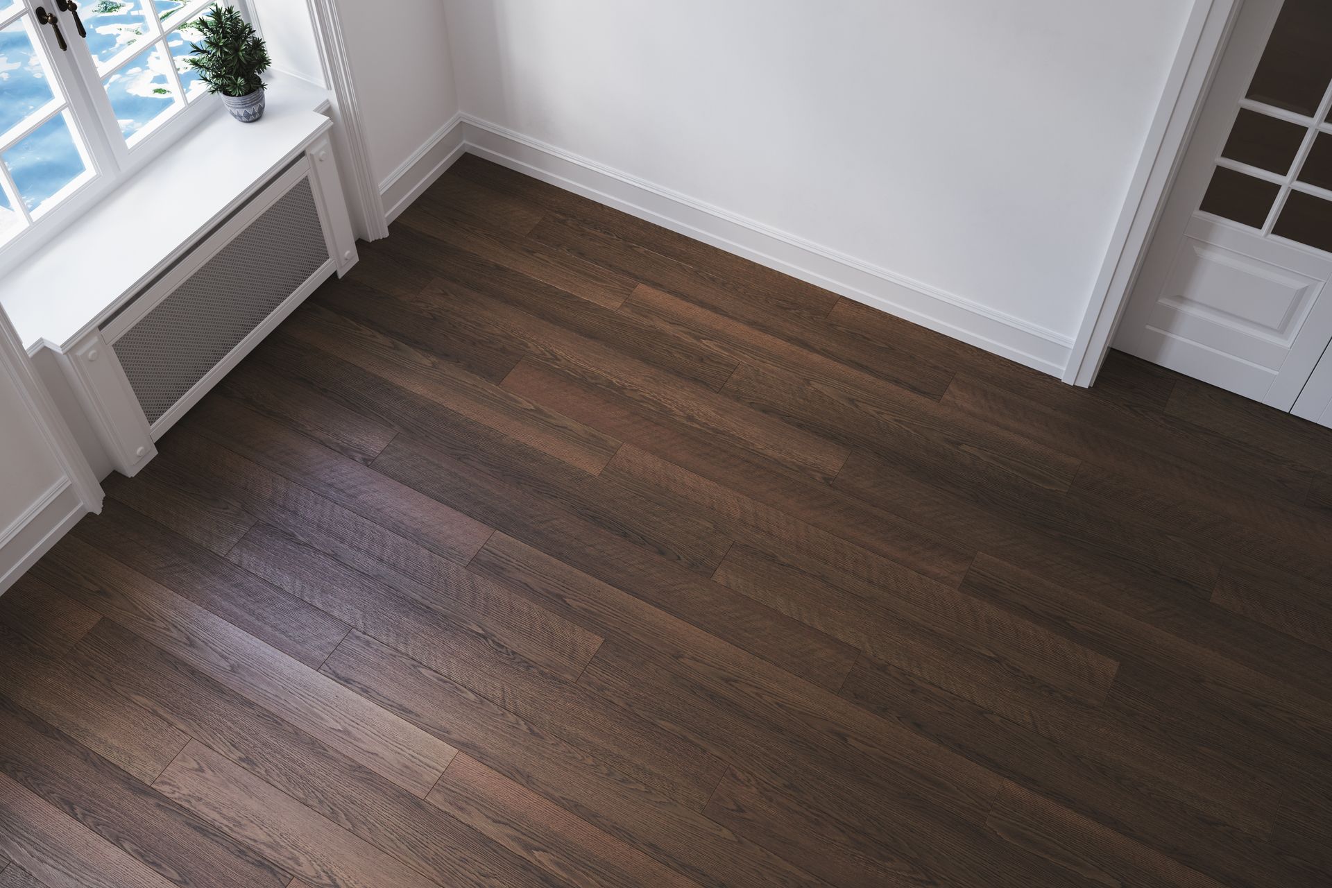 Dark wood floor in a mostly empty room with a window, white walls, and a door.